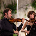 Recomanats pels professors de música, amics, coneguts o antics alumnes, tot un seguit de joves estudiants i interessats en l'àmbit de la música simfònica s'han donat cita a Cocentaina (Comtat) per gaudir de l'experiència SENT-ME durant una setmana. Procedents dels arxipèlags Canari i Balear, Catalunya, Múrcia, València o Alacant entre d'altres, els alumnes han tingut l'oportunitat de participar en activitats ben diverses i adquirir coneixements tècnics i humanístics per créixer com a músics, però també com a persones. No debades, la superació, el respecte, la reflexió i la convivència han estat els pilars fonamentals d'un festival-curs musical molt innovador.Durant la vesprada de dilluns els participants del SENT-ME varen conéixer la plantilla de professors que, durant els pròxims dies, contribuirien al seu enriquiment musical i personal. Al capdavant de l'equip, Ignacio García Vidal, organitzador del simposi, director d'orquestra, musicòleg i Doctor en Didàctica de la Direcció Musical, va estar l'encarregat de les classes de direcció musical. El contestà Jaume Llinares i l'albanés Darling Dyle assumiren la formació dels joves violins del SENT-ME; Francisco Serra, procedent del conservatori de Villena, la de les violes; Verónica Rubio i l'andalús Bruno Reyes, donaren les classes de violoncel i contrabaix respectivament. La formació dels alumnes amb instruments de vent fusta fou a càrrec de Pablo Sagredo, al capdavant de les flautes, Cayetano Castaño, amb els oboès, Eduardo Bernabeu, amb els clarinets i, finalment, Airam Déniz amb els saxos. Pel que fa al vent metall, Jesús Sánchez, Josep Olcina i Jaume Gavilán abordaren l'aprenentatge de les trompes, trompetes i trombons. Cal destacar, a més, l'especialitat d'ensenyament en música de cambra, a càrrec de la violinista internacional Anna Korpalska. Com no podia ser d'altra forma, aquest simposi també contemplà un espai per als alumnes més menuts, amb edats compreses entre els 4 i 8 anys. El "SENT-MET" va estar coordinat per Elena Huidobro, professora de piano i titulada superior en Pedagogia Musical, qui assegurà que la música esdevé fonamental per al desenvolupament personal i l'aprenentatge en la infància.Així les coses, l'Orquestra de Professors feu gala del seu talent al concert inaugural del SENT-ME, que va tindre lloc a l'escenari del Palau Comtal de Cocentaina la nit de dilluns. Tots junts, i amb la col·laboració de Rob Rowley amb les narracions, interpretaren una selecció del cèlebre "Sueño de una noche de verano" de Mendelssohn, una composició inspirada als textos literaris de William Shakespeare. 'SENT-ME', una setmana de música i germanor a Cocentaina