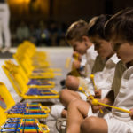 Recomanats pels professors de música, amics, coneguts o antics alumnes, tot un seguit de joves estudiants i interessats en l'àmbit de la música simfònica s'han donat cita a Cocentaina (Comtat) per gaudir de l'experiència SENT-ME durant una setmana. Procedents dels arxipèlags Canari i Balear, Catalunya, Múrcia, València o Alacant entre d'altres, els alumnes han tingut l'oportunitat de participar en activitats ben diverses i adquirir coneixements tècnics i humanístics per créixer com a músics, però també com a persones. No debades, la superació, el respecte, la reflexió i la convivència han estat els pilars fonamentals d'un festival-curs musical molt innovador.Durant la vesprada de dilluns els participants del SENT-ME varen conéixer la plantilla de professors que, durant els pròxims dies, contribuirien al seu enriquiment musical i personal. Al capdavant de l'equip, Ignacio García Vidal, organitzador del simposi, director d'orquestra, musicòleg i Doctor en Didàctica de la Direcció Musical, va estar l'encarregat de les classes de direcció musical. El contestà Jaume Llinares i l'albanés Darling Dyle assumiren la formació dels joves violins del SENT-ME; Francisco Serra, procedent del conservatori de Villena, la de les violes; Verónica Rubio i l'andalús Bruno Reyes, donaren les classes de violoncel i contrabaix respectivament. La formació dels alumnes amb instruments de vent fusta fou a càrrec de Pablo Sagredo, al capdavant de les flautes, Cayetano Castaño, amb els oboès, Eduardo Bernabeu, amb els clarinets i, finalment, Airam Déniz amb els saxos. Pel que fa al vent metall, Jesús Sánchez, Josep Olcina i Jaume Gavilán abordaren l'aprenentatge de les trompes, trompetes i trombons. Cal destacar, a més, l'especialitat d'ensenyament en música de cambra, a càrrec de la violinista internacional Anna Korpalska. Com no podia ser d'altra forma, aquest simposi també contemplà un espai per als alumnes més menuts, amb edats compreses entre els 4 i 8 anys. El "SENT-MET" va estar coordinat per Elena Huidobro, professora de piano i titulada superior en Pedagogia Musical, qui assegurà que la música esdevé fonamental per al desenvolupament personal i l'aprenentatge en la infància.Així les coses, l'Orquestra de Professors feu gala del seu talent al concert inaugural del SENT-ME, que va tindre lloc a l'escenari del Palau Comtal de Cocentaina la nit de dilluns. Tots junts, i amb la col·laboració de Rob Rowley amb les narracions, interpretaren una selecció del cèlebre "Sueño de una noche de verano" de Mendelssohn, una composició inspirada als textos literaris de William Shakespeare. 'SENT-ME', una setmana de música i germanor a Cocentaina